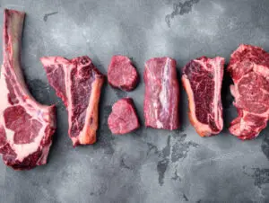 Variety of raw beef cuts on table.